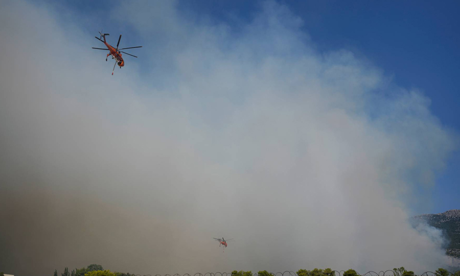 Helicopters fight the blaze in Greece. (AP) Helicopters fight the blaze in Greece. (AP)