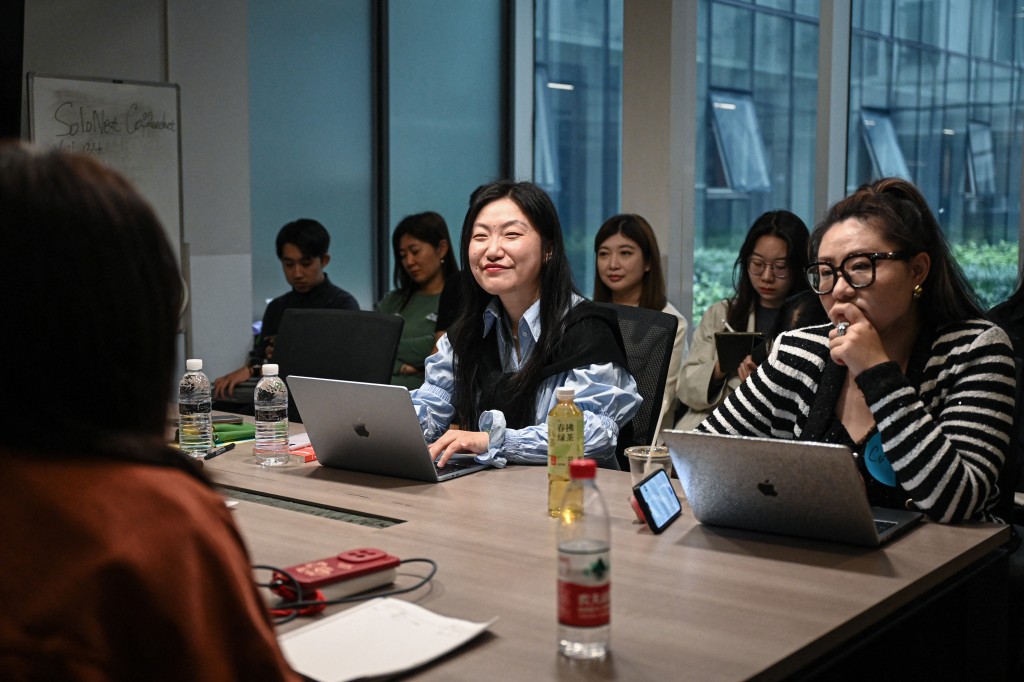 Photo by JADE GAO / AFP  The photo taken on April 12, 2026 shows founder of one-person company SoloNest Karen Dai (C) sharing her experience with participants during a coffee chat at a conference room in Shanghai.