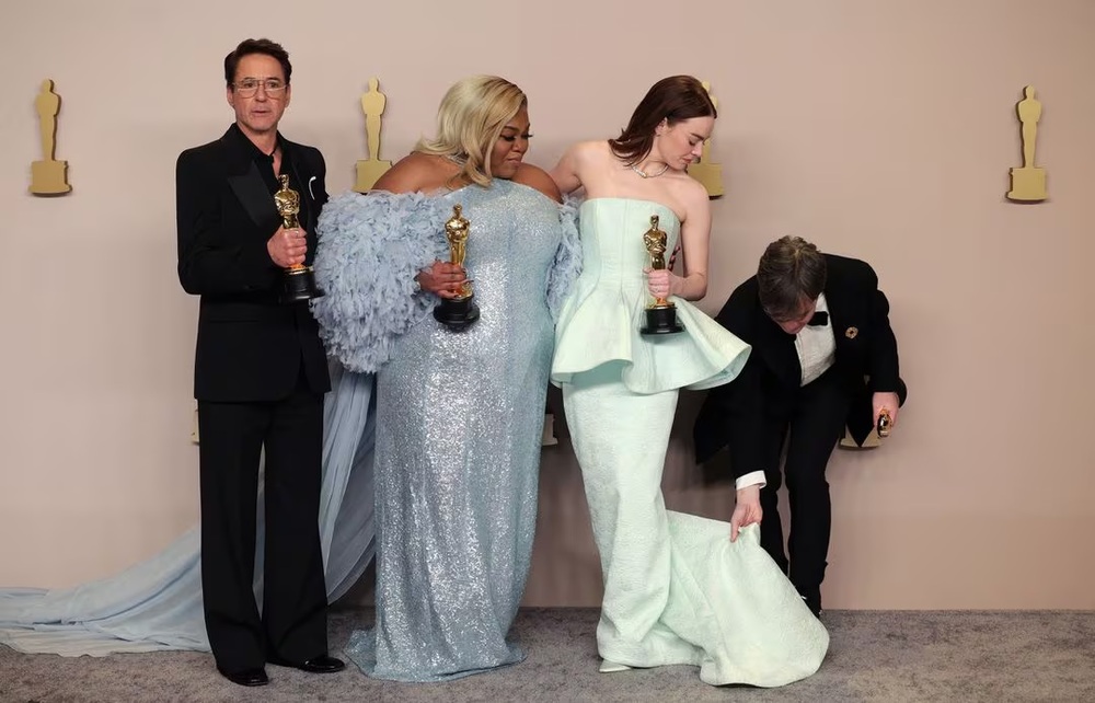 Cillian Murphy, winner of the Best Actor Oscar for 'Oppenheimer', adjusts the dress of Emma Stone, winner of the Best Actress Oscar for 'Poor Things', as they pose with Da'Vine Joy Randolph, Best Supporting Actress Oscar winner for 