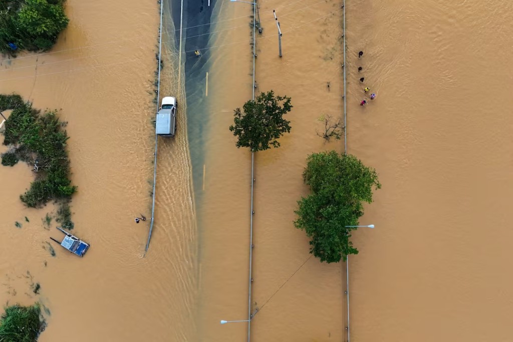A drone view shows people wading through a flooded area in Hat Yai district, affected by deadly flooding following heavy rainfall in southern Thailand. REUTERS/Athit Perawongmetha