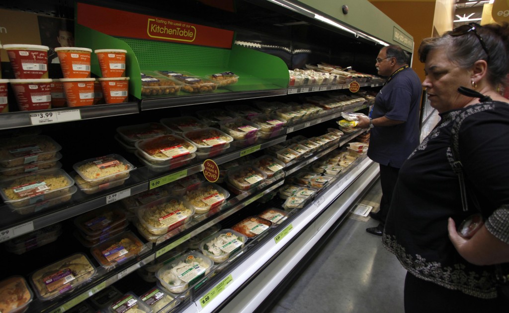 Shoppers look at items inside a Tesco's Fresh & Easy Neighborhood Market food store including family size packs of food which serve four people and cost eight dollars each in Compton, California, May 13, 2009. Reuters