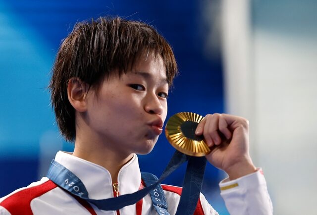 Paris 2024 Olympics - Diving - Women's 10m Platform Victory Ceremony - Aquatics Centre, Saint-Denis, France - August 06, 2024. Gold medallist Hongchan Quan of China celebrates with her medal on the podium. REUTERS/Lisa Leutner