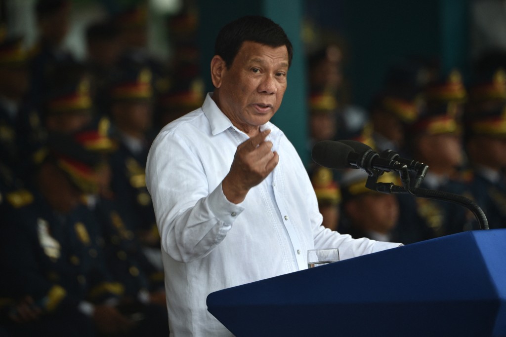 Photo by TED ALJIBE / AFP  Philippine President Rodrigo Duterte delivers his speech during the 117th police anniversary celebration at the national headquarters in Manila on August 8, 2018.