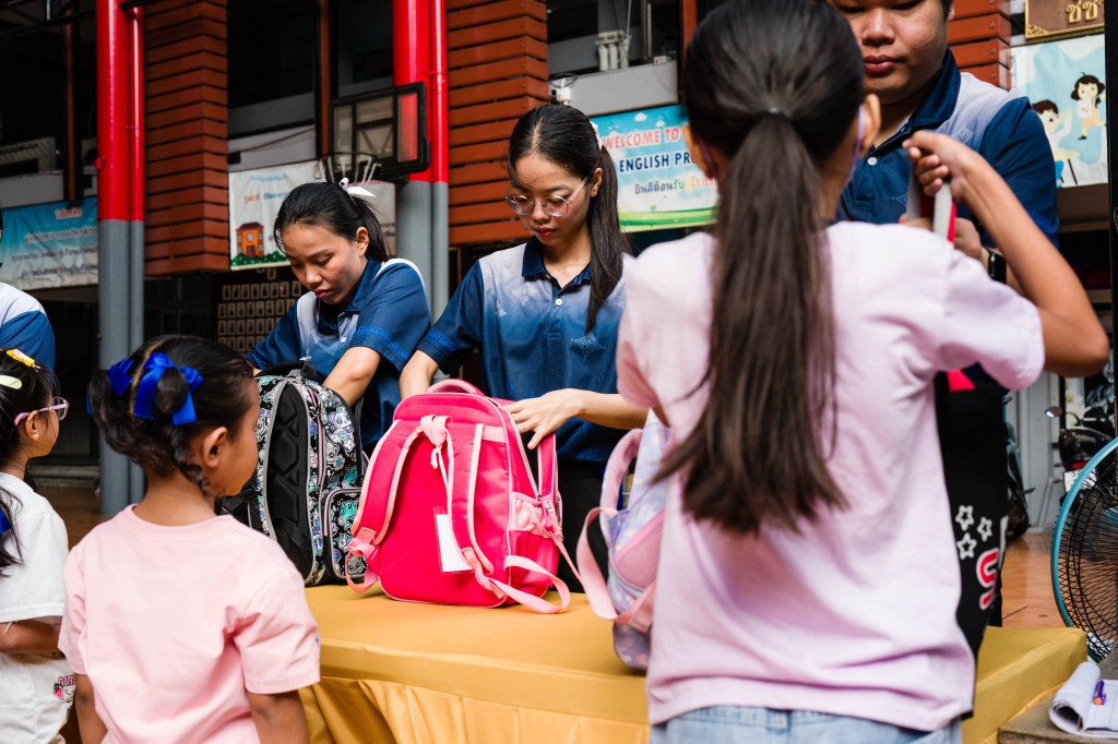 Photo by ANTHONY WALLACE / AFP Staff inspect backpacks due to new security measures as students arrive at Sawasdee Wittaya School in Bangkok on August 14, 2026.