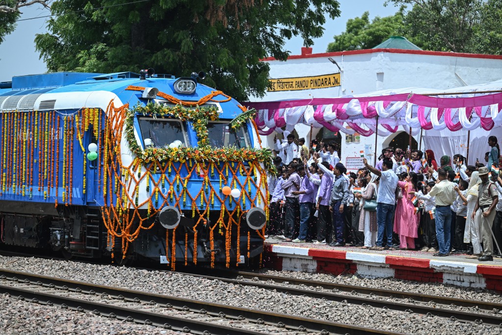 Photo by ARUN SANKAR / AFP  People shower flower petals as the Indian Railways' hydrogen-powered train arrives at Pandu Pindara railway station after its flagging-off ceremony in Haryana's Jind city on July 17, 2026.