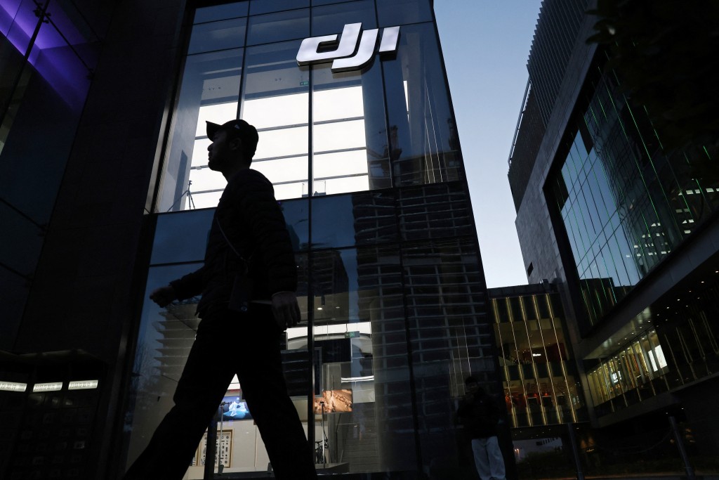 A man walks past a DJI flagship store during evening hours in Beijing, China March 27, 2025. REUTERS/Florence Lo