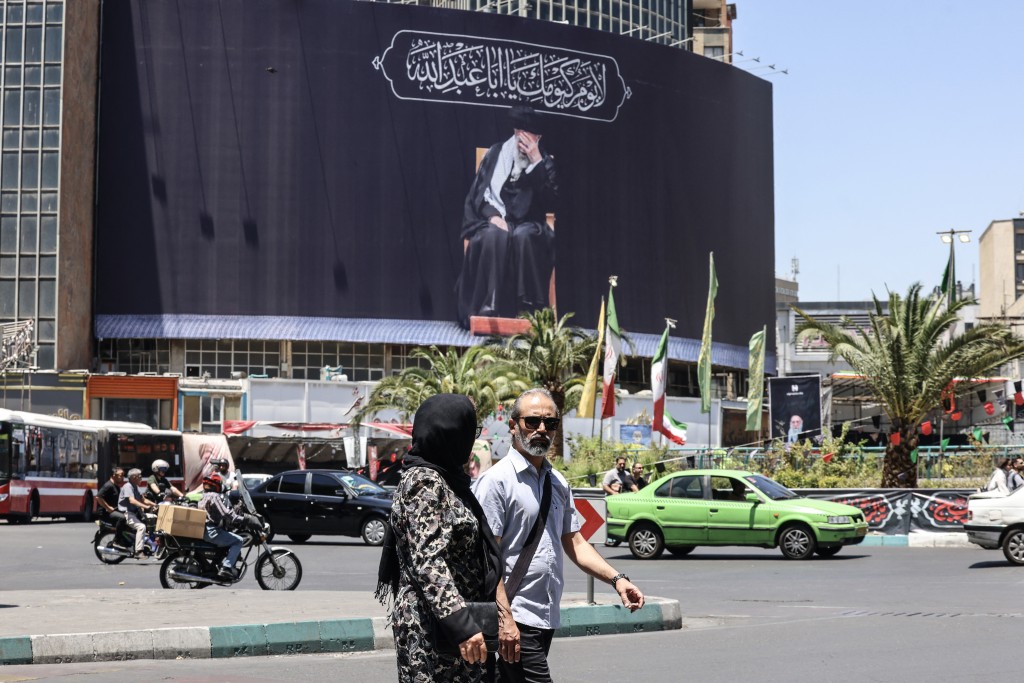Iranians walk past a billboard depicting slain supreme leader Ayatollah Ali Khamenei at Valiasr Square in Tehran on June 15, 2026. (AFP)