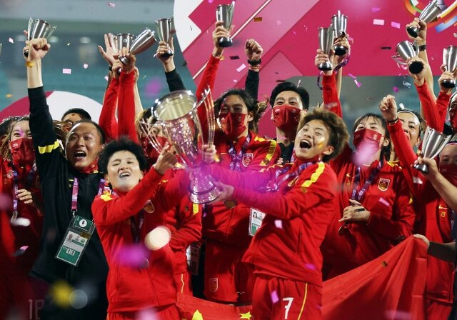 Soccer Football - Women's Asian Cup 2022 - Final - China v South Korea - D Y Patil Sports Stadium, Navi Mumbai, India - February 6, 2022 China's Wang Shuang and Wang Shanshan hold the trophy and celebrate with team members after the match REUTERS/Francis Mascarenhas/File Photo