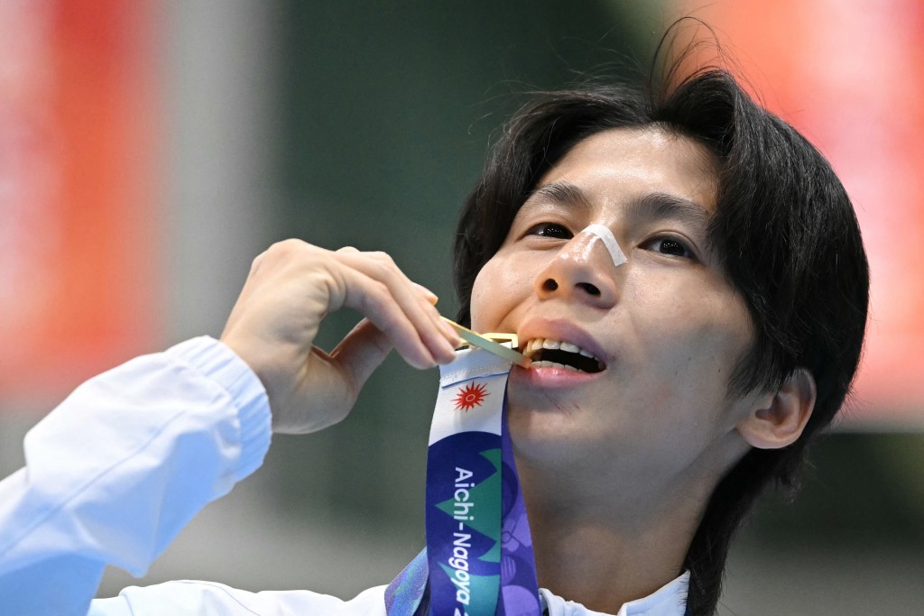 Gold medallist Taiwan's Lin Yu-ting celebrates on the podium after the women's 60kg boxing event during the 2026 Asian Games at Nishio Gymnasium in Nishio on October 2, 2026. (Photo by MOHD RASFAN / AFP)