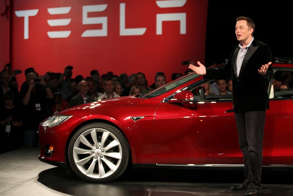 Tesla Motors CEO Elon Musk speaks next to the company's newest Model S during the Model S Beta Event held at the Tesla factory in Fremont, California October 1, 2011. REUTERS/Stephen Lam/File Photo