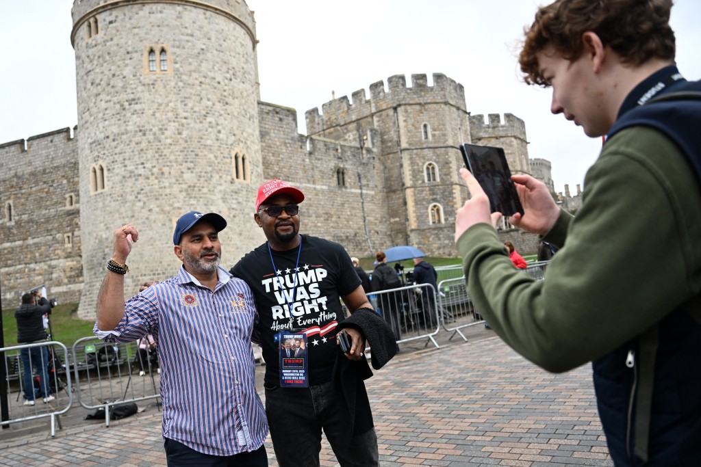 A supporters of US President Donald Trump poses for a photograph outside Windsor Castle, in Windsor, on September 17, 2025, during US President Donald Trump's second State Visit to the UK. US President Donald Trump arrived in Britain on Tuesday for an unprecedented second state visit, with the UK government rolling out a royal red carpet welcome to win over the mercurial leader. (Photo by Paul ELLIS / AFP)