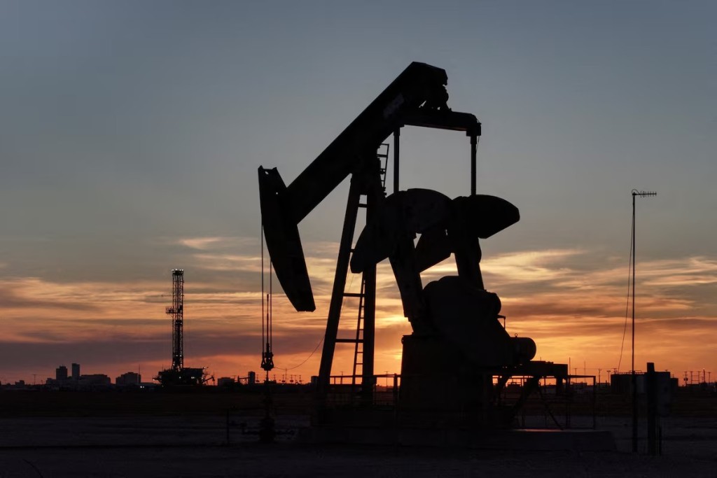 A drone view of a pump jack and drilling rig south of Midland, Texas, U.S. June 11, 2025. REUTERS