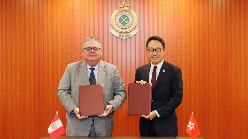 Mr. Chan Tsz-tat (right) exchanging the signed document with Peruvian Consul-General (left). HK Customs