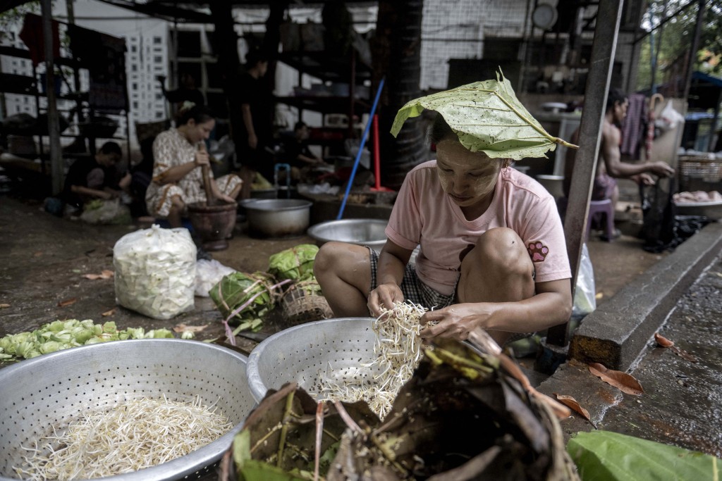 Photo by SAI AUNG MAIN / AFP  A woman prepares ingredients to cook at a Rakhine traditional food restaurant in Yangon on May 15, 2026.