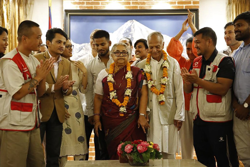 Nepal's newly appointed Prime Minister Sushila Karki (C) is congratulated by her supporters after the swearing-in-ceremony at the President House in Kathmandu on September 12, 2025. Nepal's former chief justice Sushila Karki was sworn on September 12 to lead the transition as the country's next prime minister after deadly anti-corruption protests ousted the government. (Photo by Sujan GURUNG / AFP)
