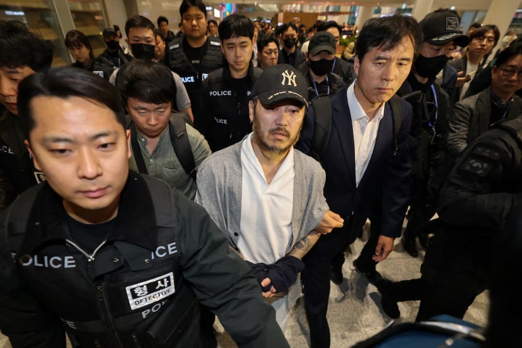 Park Wang-yeol, an alleged "drug lord” who was serving a 60-year term in a Philippines prison for the murder of three South Koreans and who is accused of running a drug trafficking ring in the country from the prison, walks as he is escorted by detectives upon his arrival at the Incheon International airport in Incheon, South Korea, March 25, 2026. Yonhap via REUTERS