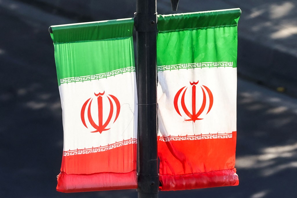 Iranian flags hang off a lamp post along a street in southern Tehran on June 20, 2026. (Photo by ATTA KENARE / AFP)