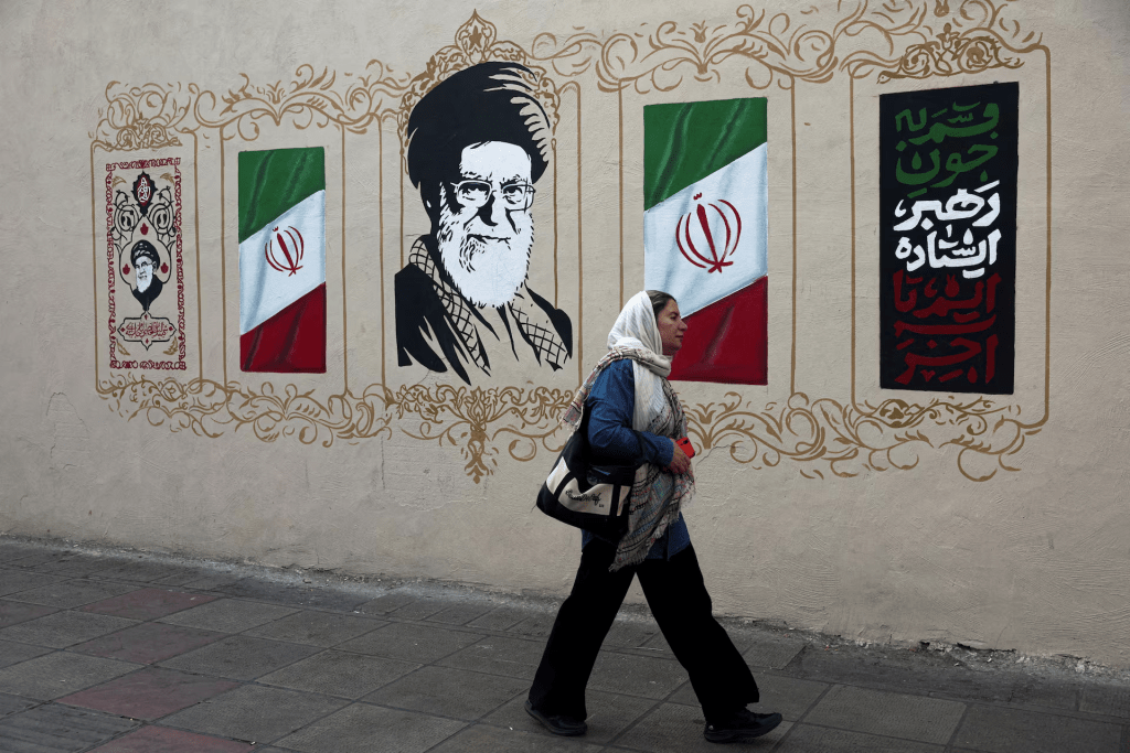 A woman walks by a mural depicting Iran's late Supreme Leader Ayatollah Ali Khamenei, on a street in Tehran, Iran, August 13, 2026. Majid Asgaripour/WANA (West Asia News Agency) via REUTERS/File Photo