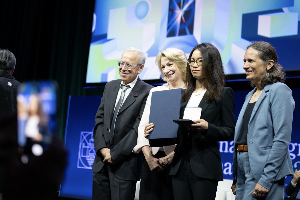 Photo by ERIN BLEWETT / AFP  Jalal Shatah, Marilyn Simons, 2026 Fields Medalist Chinese mathematician Hong Wang and Deirdre Haskell pose for photos after Wang received the 2026 Fields Medal during the International Congress of Mathematicians in Philadelphia, on July 23, 2026.