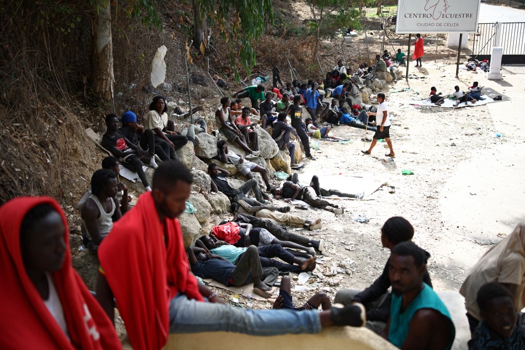 Migrants sit outside the CETI short-stay migrant centre in the Spanish North African enclave of Ceuta on August 1, 2026. (AFP)