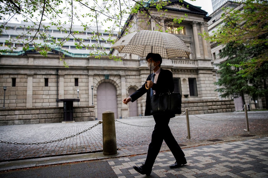 An office employee walks in front of the bank of Japan building in Tokyo, Japan, April 7, 2023. REUTERS