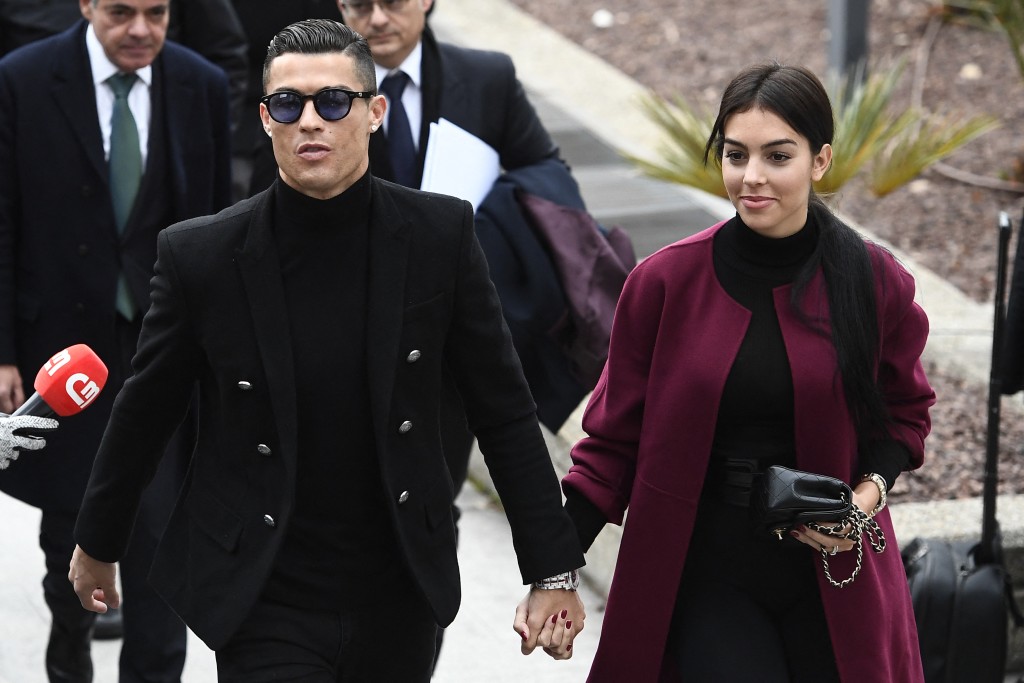 Photo by PIERRE-PHILIPPE MARCOU / AFP Juventus' forward and former Real Madrid player Cristiano Ronaldo (L) arrives with his Spanish girlfriend Georgina Rodriguez (R) to attend a court hearing for tax evasion in Madrid on January 22, 2019.