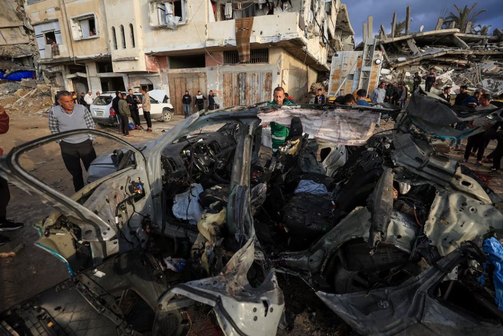 Palestinians inspect the site of an Israeli strike on a car in Gaza City, December 13, 2025. (REUTERS/Dawoud Abu Alkas)