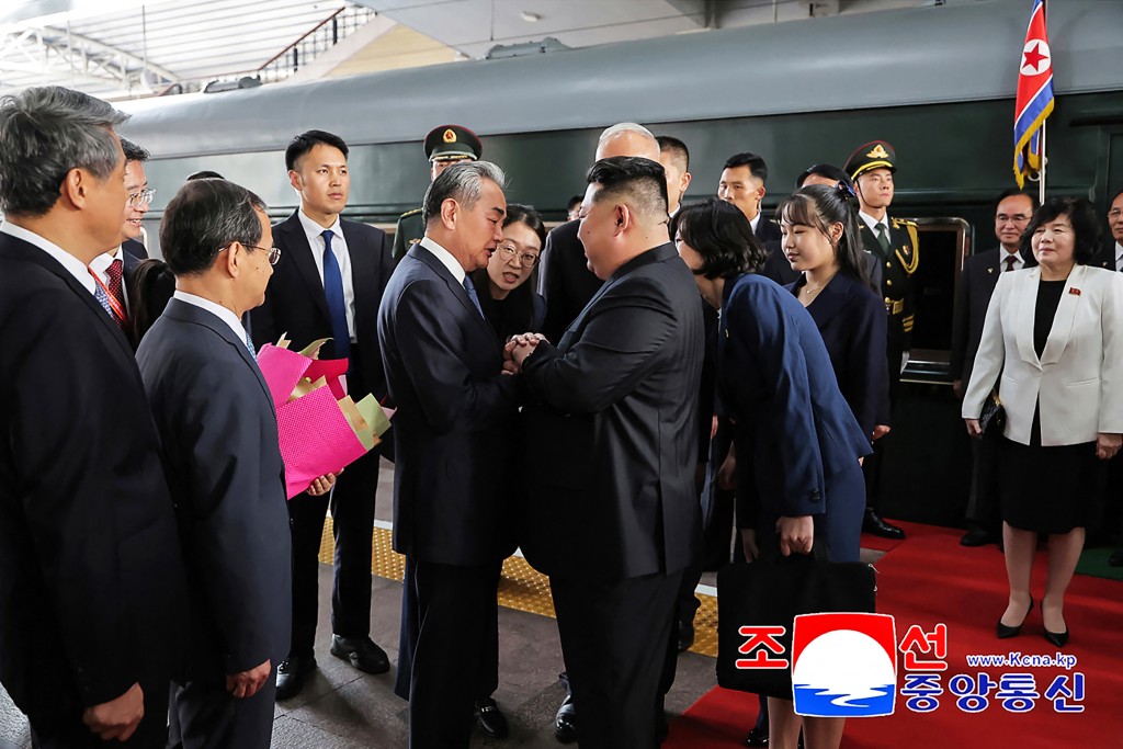 This photograph taken on September 2, 2025 and released by North Korea's official Korean Central News Agency (KCNA) via KNS shows North Korea's leader Kim Jong Un (centre R) and his daughter Kim Ju Ae (4th R) being greeted by China's Foreign Minister Wang Yi (centre L) upon their arrival at the Beijing Railway Station in Beijing. (Photo by KCNA VIA KNS / AFP)