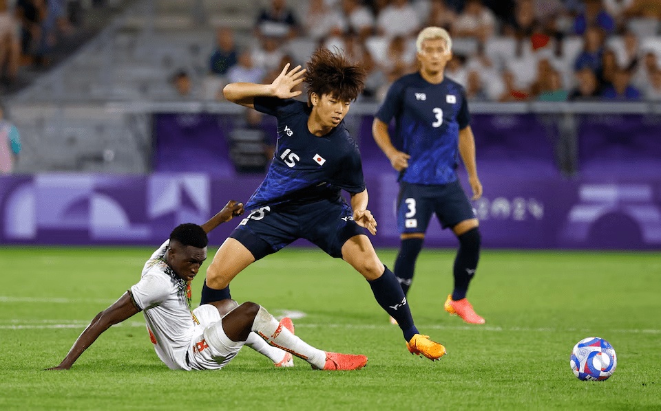 Paris 2024 Olympics - Football - Men's Group D - Japan vs Mali - Bordeaux Stadium, Bordeaux, France - July 27, 2024. Kota Takai of Japan in action with Boubacar Traore of Mali. REUTERS/Susana Vera 
