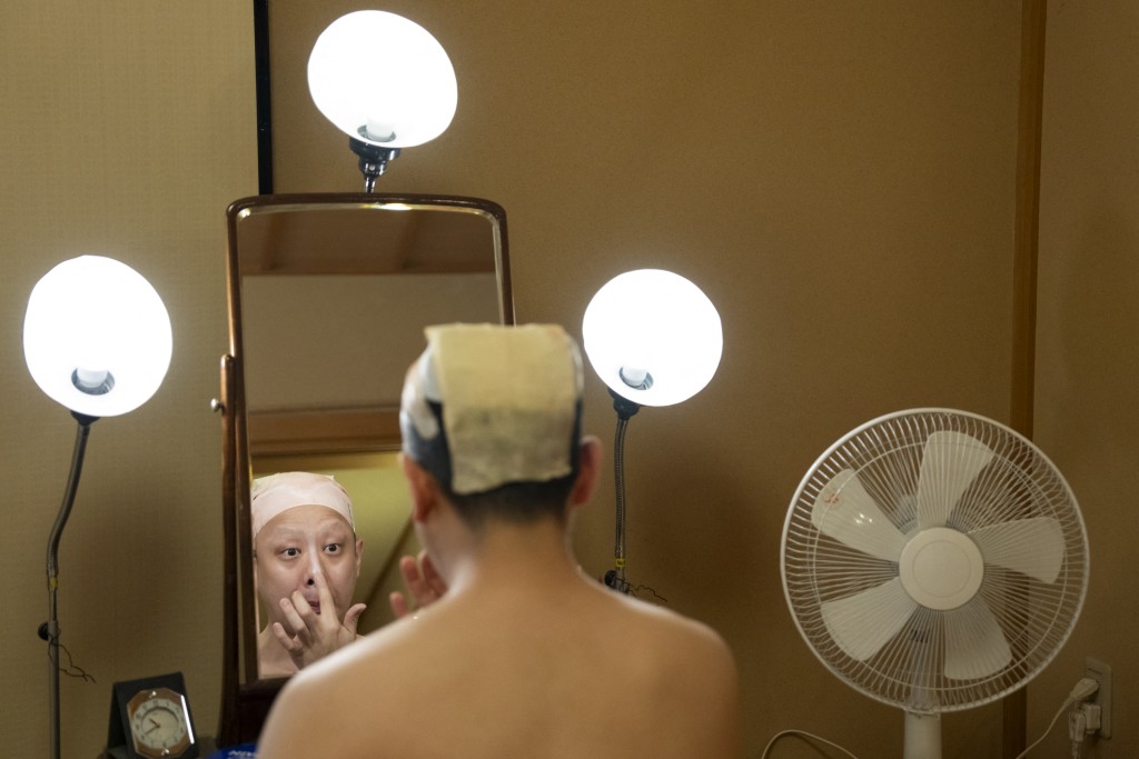 Photo by YUICHI YAMAZAKI / AFP  This picture taken on April 13, 2026 shows kabuki actor Tanenosuke Nakamura applying makeup before his performance at the Kabuki-za Theatre in Tokyo.