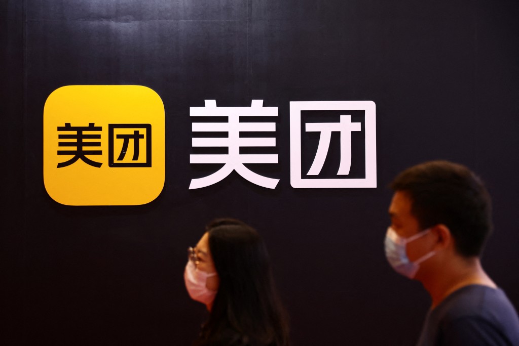 People walk past a logo of Meituan in Beijing, China August 18, 2022. REUTERS//Tingshu Wang