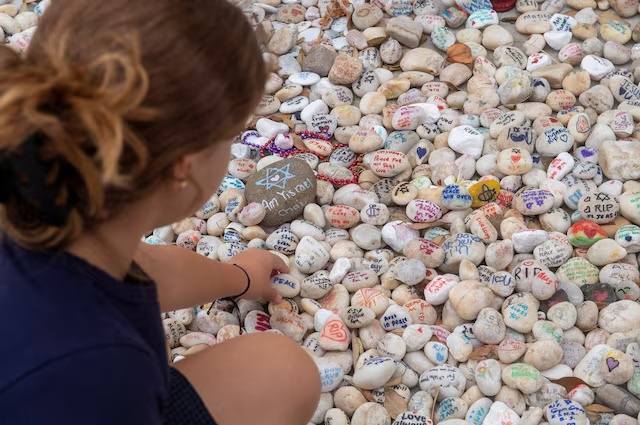 A visitor places a pebble at a memorial site in remembrance to the lives lost during the Bondi Beach mass shooting on December 14, 2025, in Sydney, Australia, January 16, 2026. REUTERS/Jeremy Piper