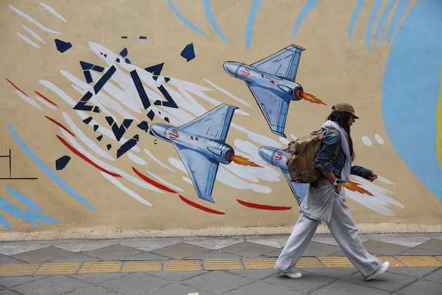 An Iranian woman walks next to an anti-Israeli mural on a street in Tehran, Iran, May 5, 2026. Majid Asgaripour/WANA (West Asia News Agency) via REUTERS
