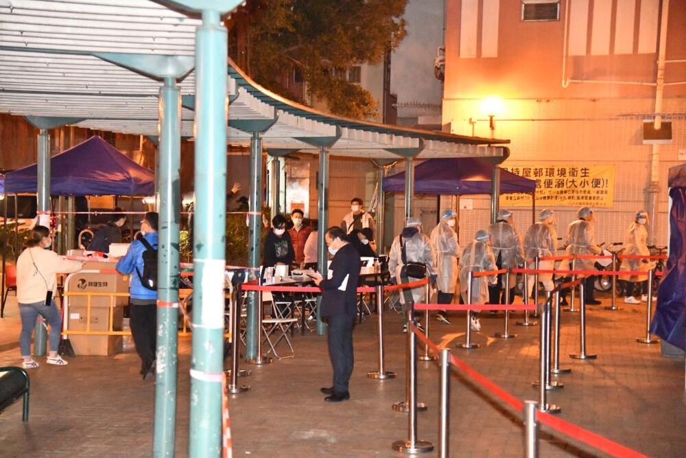 Residents come downstairs for the compulsory testing.