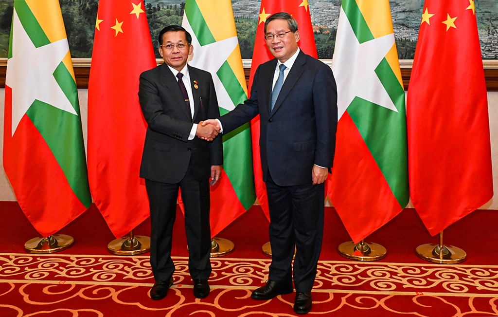 Photo by HANDOUT / MYANMAR MILITARY INFORMATION TEAM / AFP  This handout picture taken on November 6, 2024 and released by the Myanmar Military Information Team shows Myanmar's military chief Min Aung Hlaing (L) shaking hands with China's Primier Li Qiang (R) ahead of a dinner reception during the Greater Mekong Subregion (GMS) Summit in Kunming, southern China's Yunnan Province.