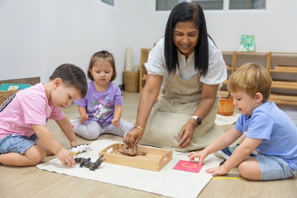 In a vibrant Montessori classroom, our guide engages young children with hands-on learning activities that encourage interaction and foster curiosity.