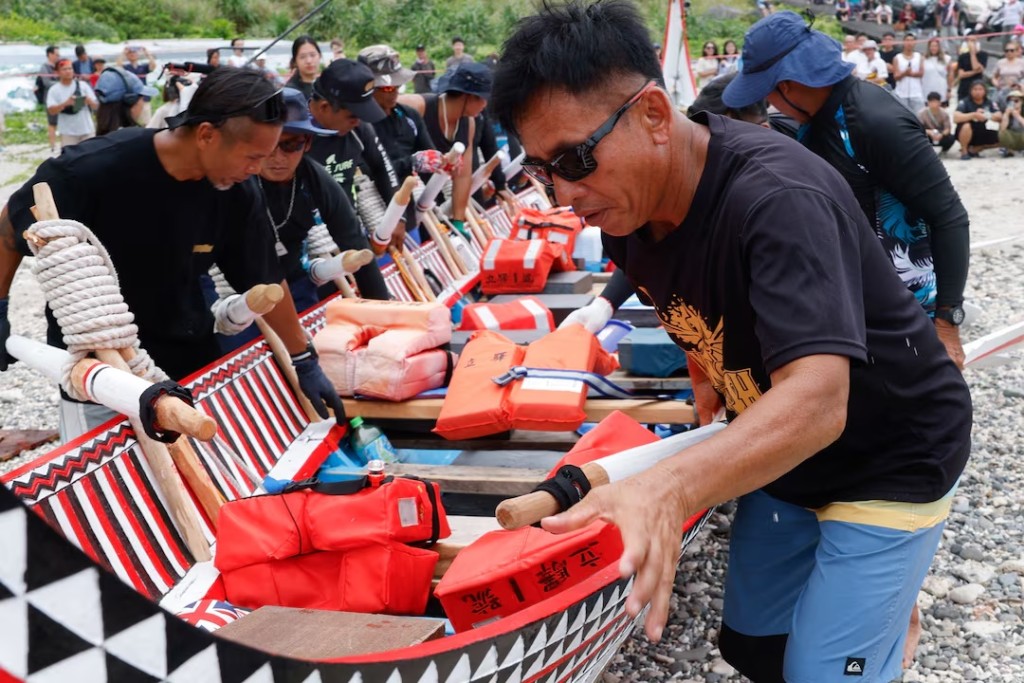 Tao indigenous rowers push a traditional wooden canoe named Ovayan, or "Golden Friendship," into the water as they prepare to paddle to the Philippines' Batanes Islands, on Orchid Island, Taiwan, June 15, 2026. REUTERS/Ann Wang