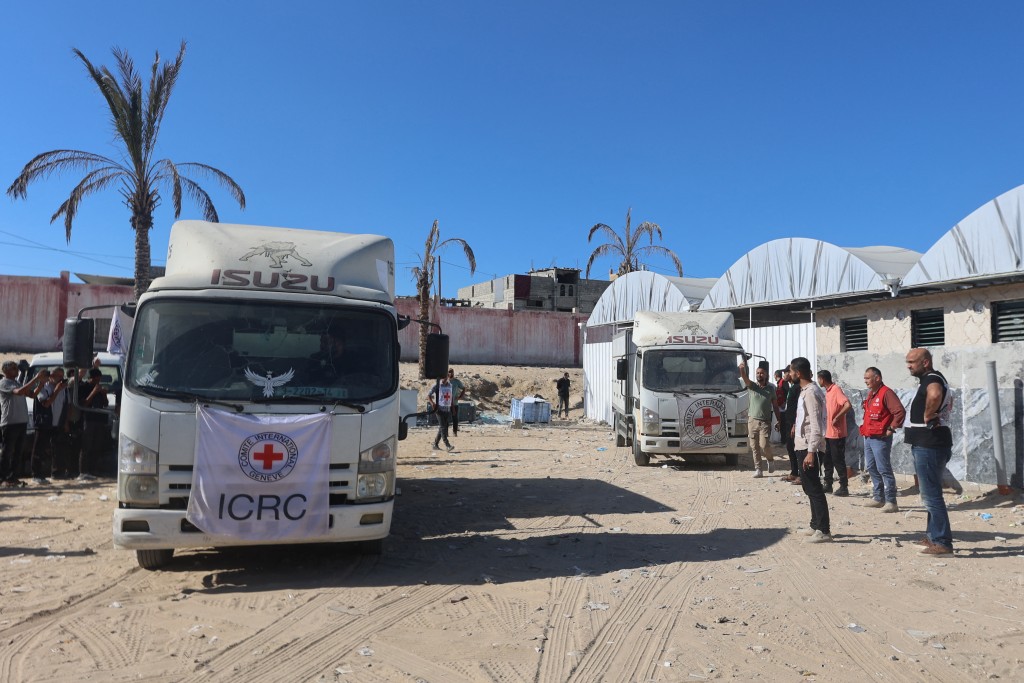 Red Crescent vehicles and refrigerated trucks are parked at the Nasser hospital in Khan Yunis in the southern Gaza Strip on October 15, 2025, after transporting the bodies of Palestinians that had been in Israeli custody.  Photo by OMAR AL-QATTAA / AFP