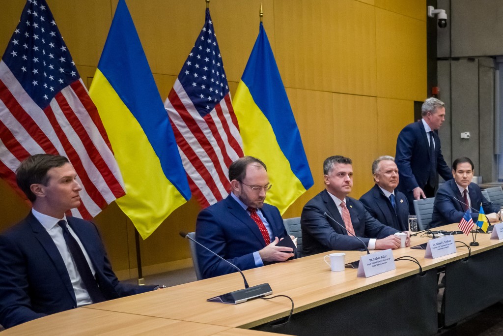 Photo by FABRICE COFFRINI / AFP US Secretary of State Marco Rubio (5th L), US special envoy Steve Witkoff (4th L), US Secretary of the Army Daniel Driscoll (taking his seat) and US President Donald Trump's son-in-law Jared Kushner (L) face the Ukrainian delegation during discussions on a US plan to end the war in Ukraine at the US Mission in Geneva, on November 23, 2025.