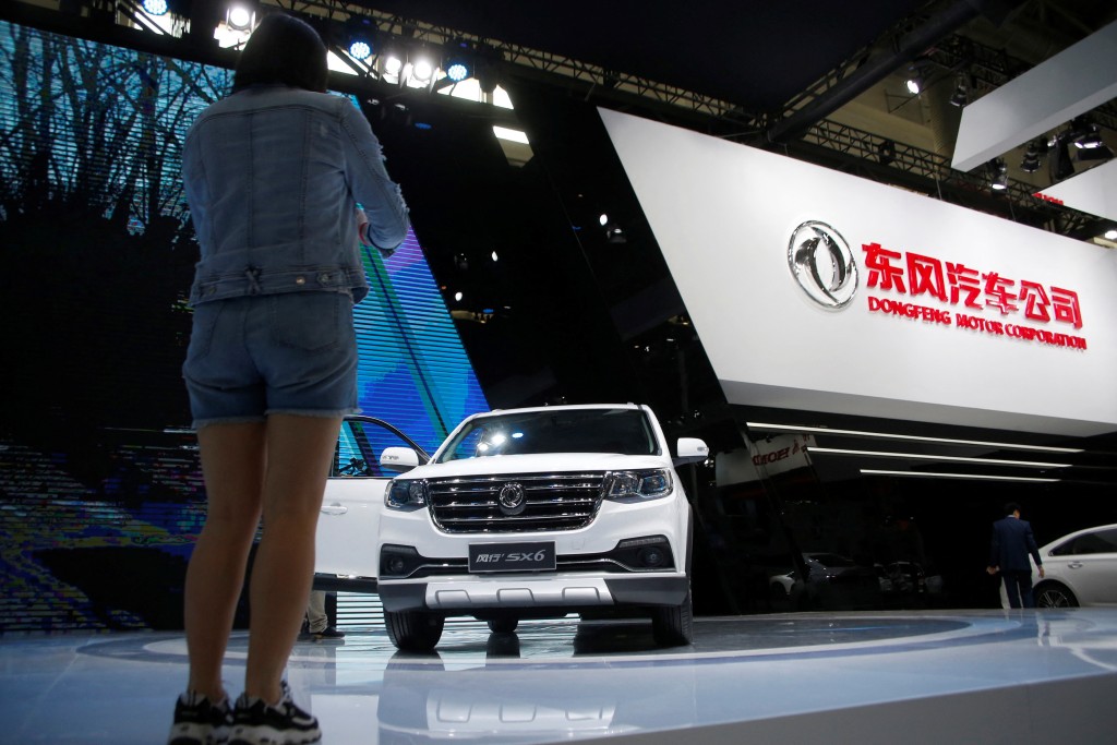 A woman takes picture of  Dongfeng Motor Corp SX6 SUV model at the Auto China 2016 auto show in Beijing, China, April 26, 2016. REUTERS