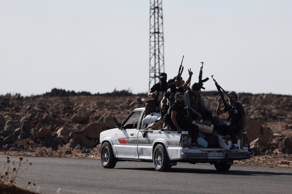 Bedouin fighters ride a car, following renewed fighting between Bedouin fighters and Druze gunmen, despite an announced truce, in Sweida, Syria July 18, 2025. REUTERS/Khalil Ashawi