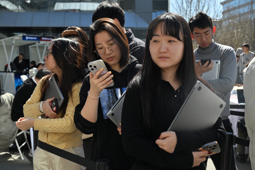 People queue to have their laptops install with OpenClaw, an open-source AI assistant at the Baidu headquarter in Beijing on March 11, 2026. (Photo by ADEK BERRY / AFP)