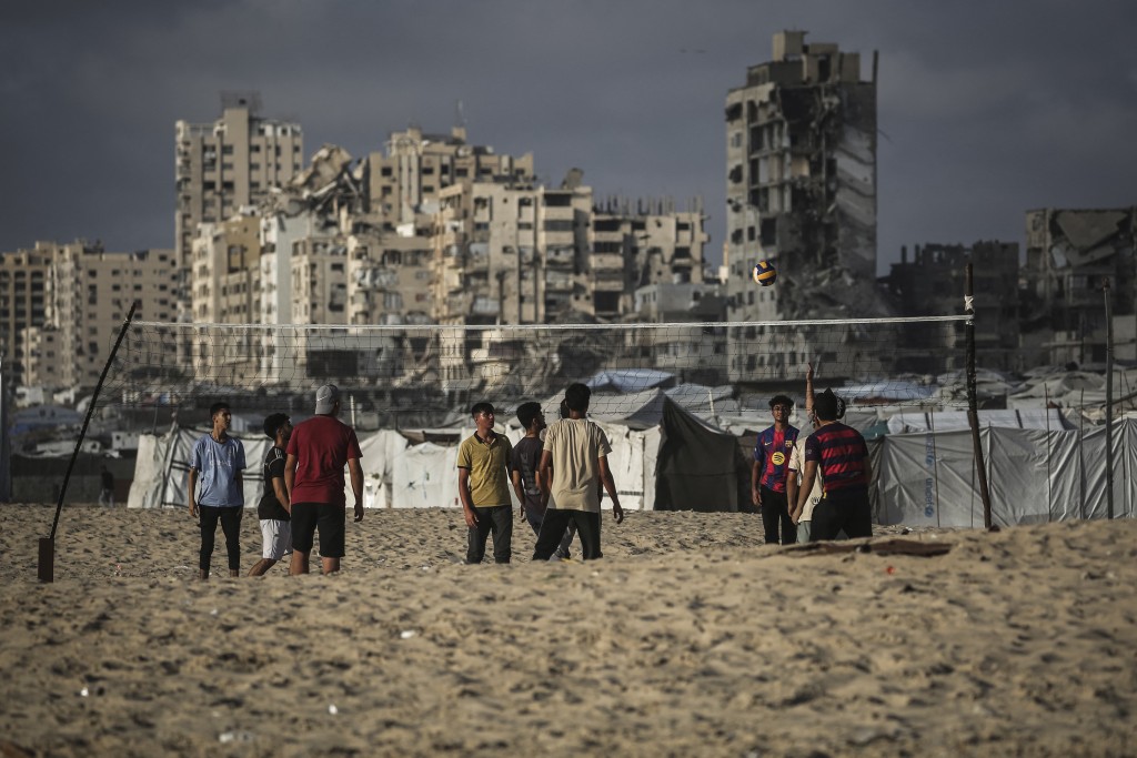 Photo by EYAD BABA / AFP. Palestinians play volley ball along on the beach front in Gaza City on July 3, 2026.