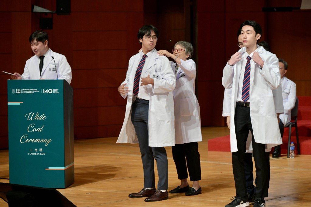 Professors from the Faculty of Medicine draped white coats over the new medical students. Pictured in the center is Vincent Ng Ka-wing, this year's DSE "super top scorer."