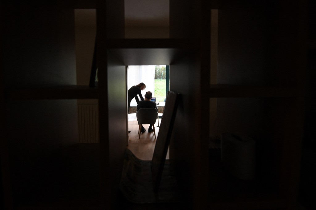 A carer speaks with an elderly resident - one of three alzheimer sufferers in the establishment- in a house at L'Hay-les- Roses on the outskirts of Paris on February 17, 2022. (Photo by ALAIN JOCARD / AFP)