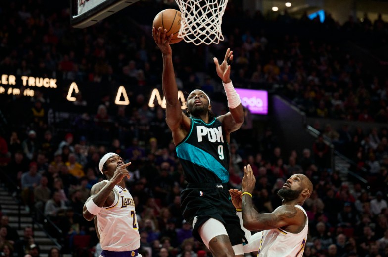 Blazers forward Jerami Grant scores a basket during the first half against LeBron James and Jarred Vanderbilt, left.  REUTERS