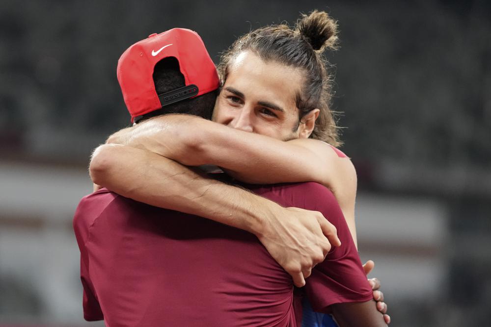 In this Aug. 1, 2021, file photo, Gianmarco Tamberi, of Italy, embraces fellow gold medalist Mutaz Barshim, of Qatar, after the final of the men's high jump at the 2020 Summer Olympics in Tokyo. In an extraordinary Olympic Games where mental health has been front and center, acts of kindness are everywhere.