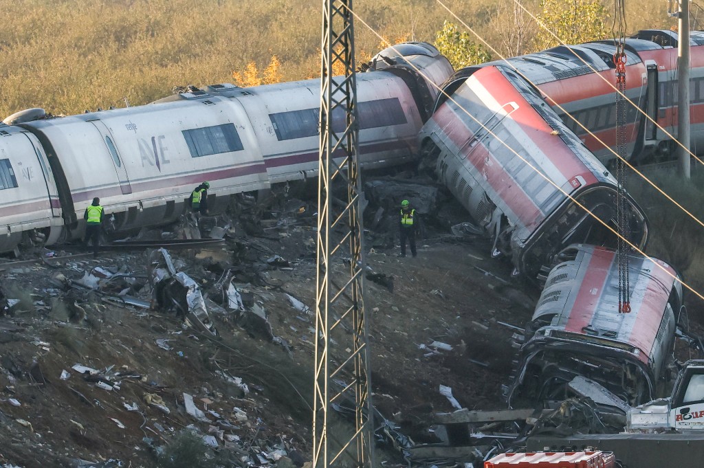 Photo by OSCAR DEL POZO / AFP  Investigators survey debris amongst the damaged carriages of a train crash between two high-speed units, a Renfe AVE train and an Iryo train around 150 km south of Madrid between Urda and Los Yebenes in the province of Toledo, a day after the accident on October 29, 2026.