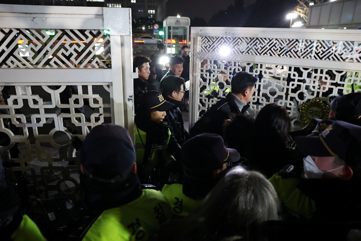 People react as police close the gate of the National Assembly in Seoul, South Korea. (Reuters)
