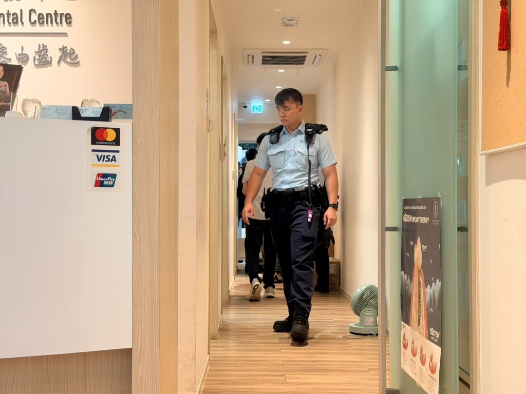 Police officers investigate inside the dental clinic.
